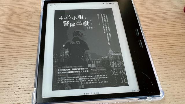 An e-reader on a wooden table displaying the cover of a book written in Traditional Chinese. The cover shows a man in a police uniform, turning his back to the camera with a city outline as background, but the quality is not very high and details are hard to see. 