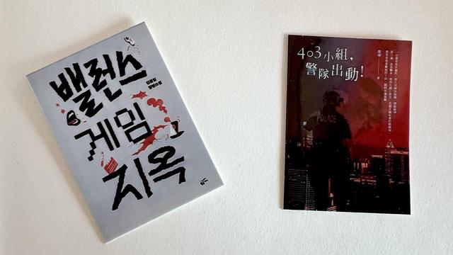Two stickers of book covers on a blank page. The sticker on the left is a Korean book with a grey cover, and on the right, it’s a Taiwanese book with a dark cover showing a police officer. 