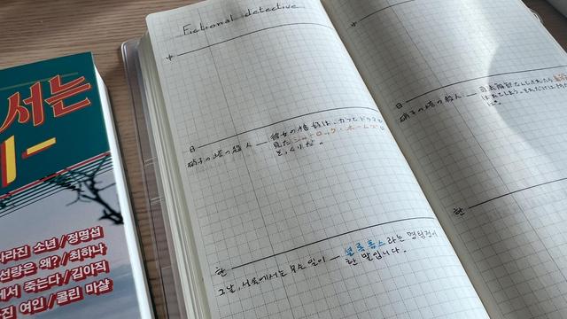 A long and thin grid notebook opened: The pages have three lines making three sections. The title on the left page is “fictional detective”. The second and third sections have notes in Japanese and Korean respectively with a word highlighted. 