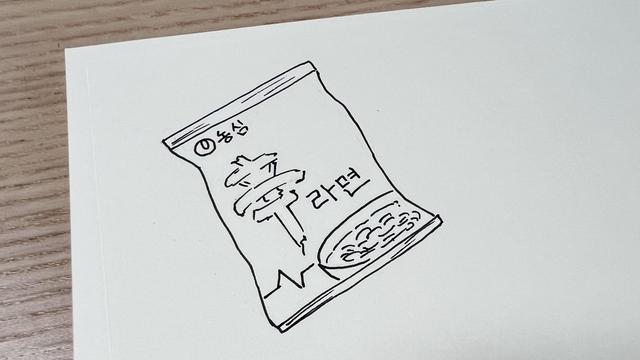 Top left part of a page with a doodle of an instant noodle packaging from a Korean brand. 