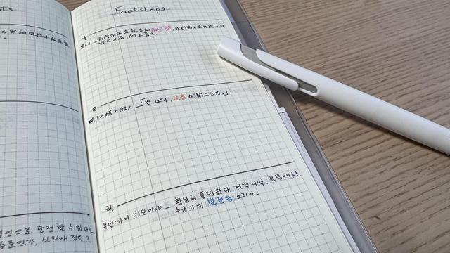An opened, long and thin grid agenda. The right page has the title “footsteps” and is divided into three sections, each filled with a quote in Chinese for the top section, Japanese for the middle one, and Korean for the bottom one. 