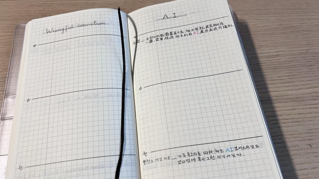 An open grid notebook. Left page has the title “wrongful conviction “ and the right page “AI”. They are both divided into three sections. The “AI” page has a book title and a quote in two of its sections. The rest is empty. 